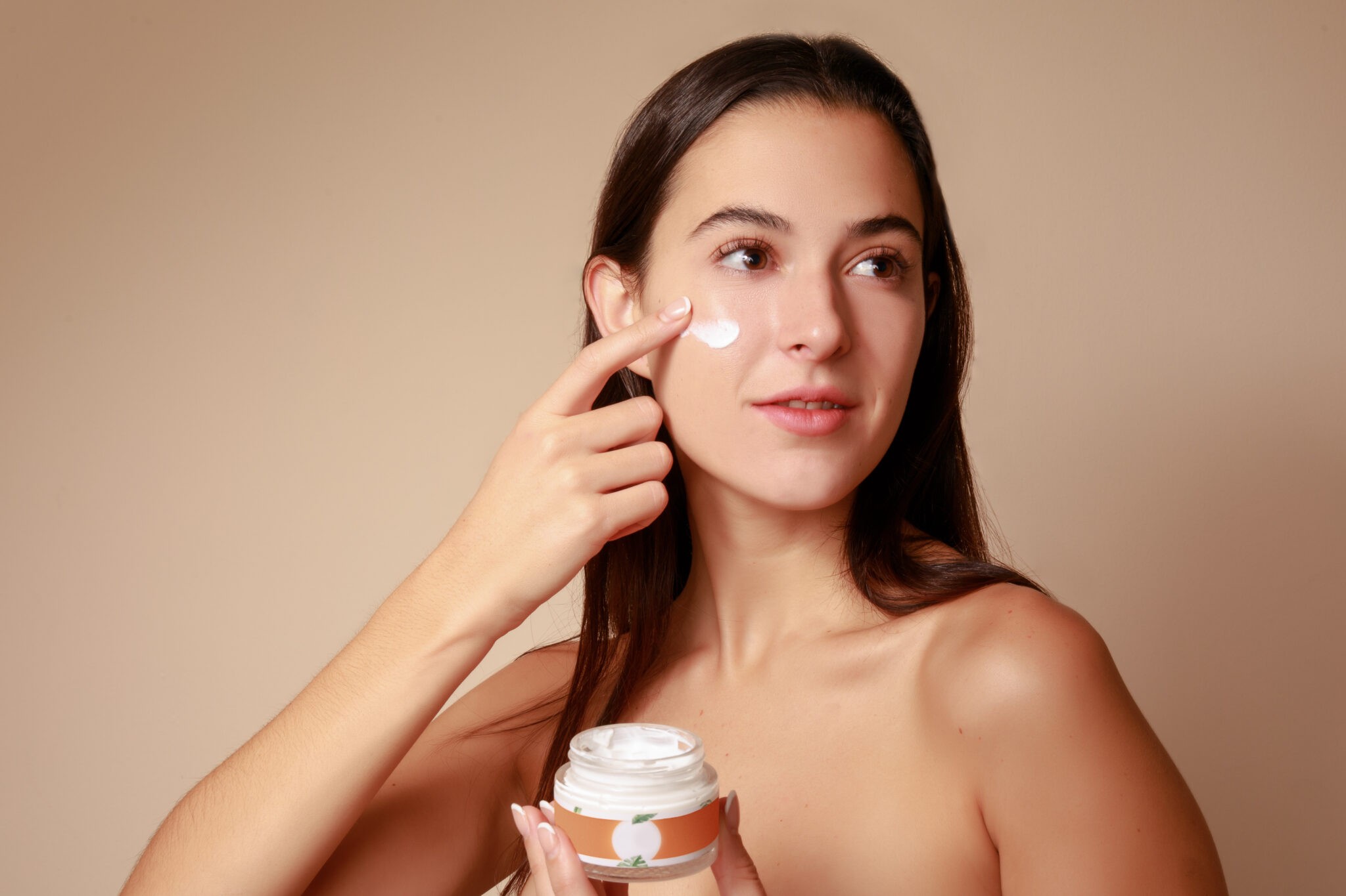 Joven Mujer mexicana aplicando crema humectante facial producto