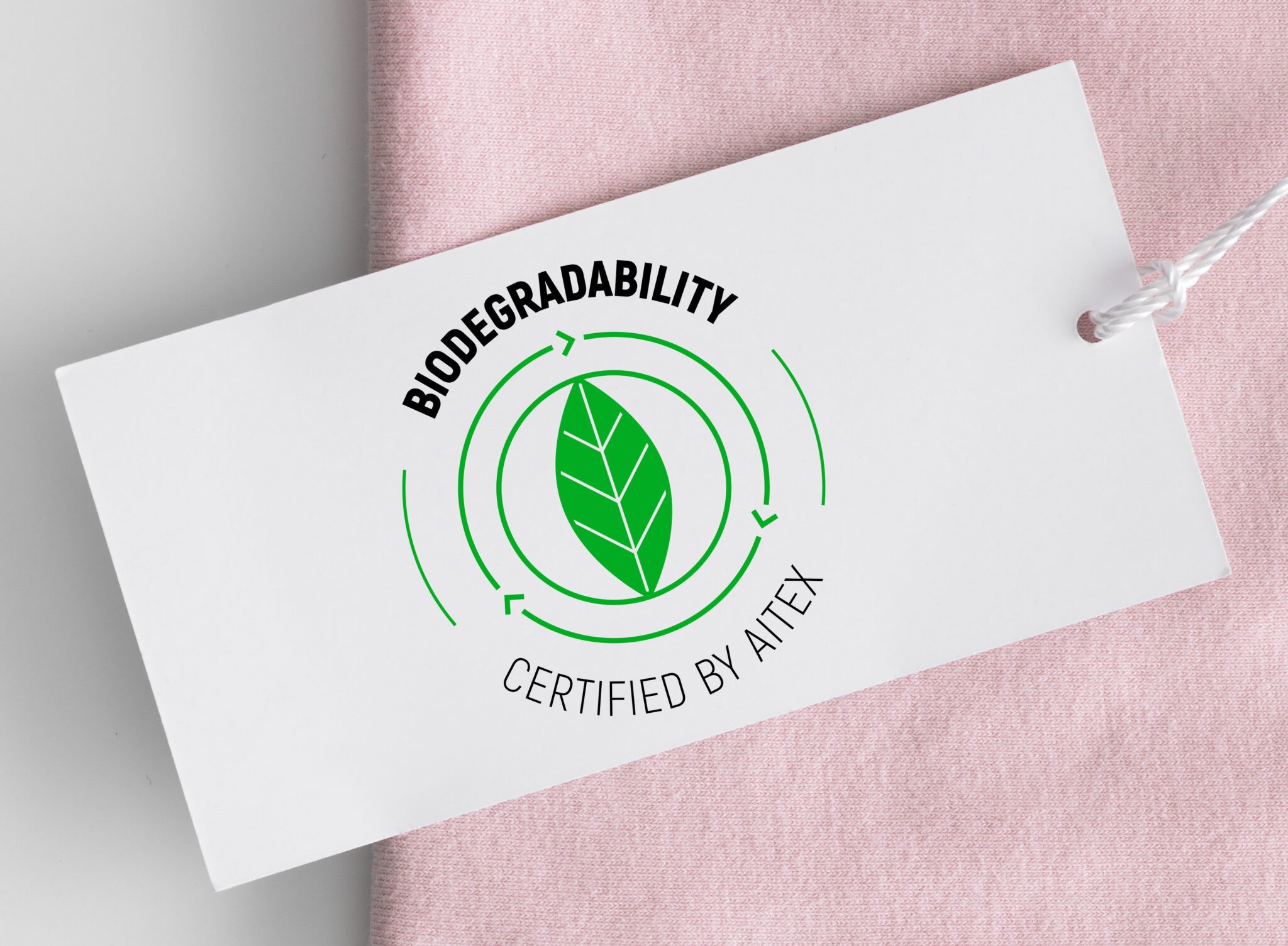 White clothing tag mockup on a soft pink t-shirt.